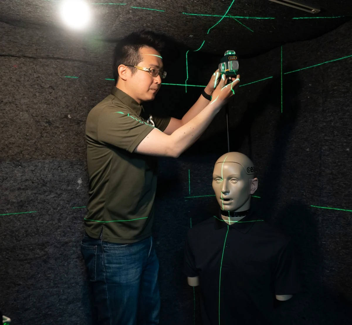 音響測定用マネキンのそばで、スタッフが測定の準備をする様子